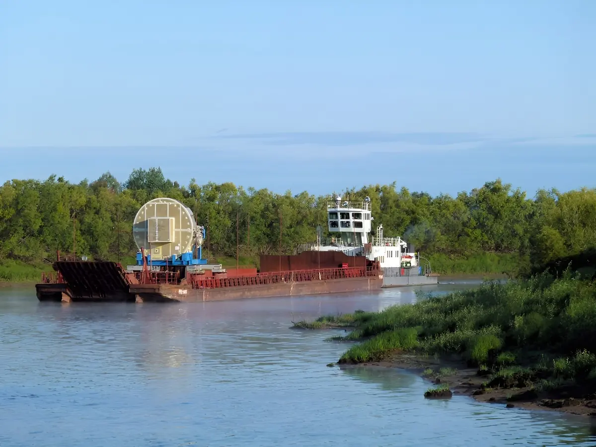 A tugboat pushes a cargo barge along the Irtysh River.