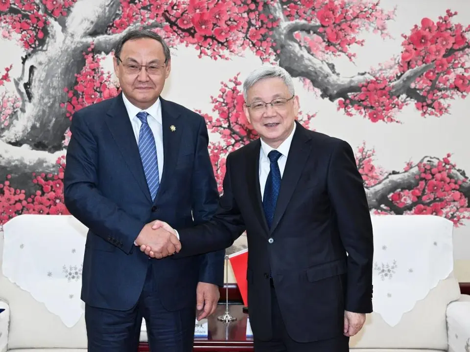 The president of the Chinese Academy of Sciences, Hou Jianguo (right), and his Kazakh counterpart, Akhylbek Kurishbayev, shake hands in Beijing on August 18 after agreeing to expand cooperation on AI in several areas.
