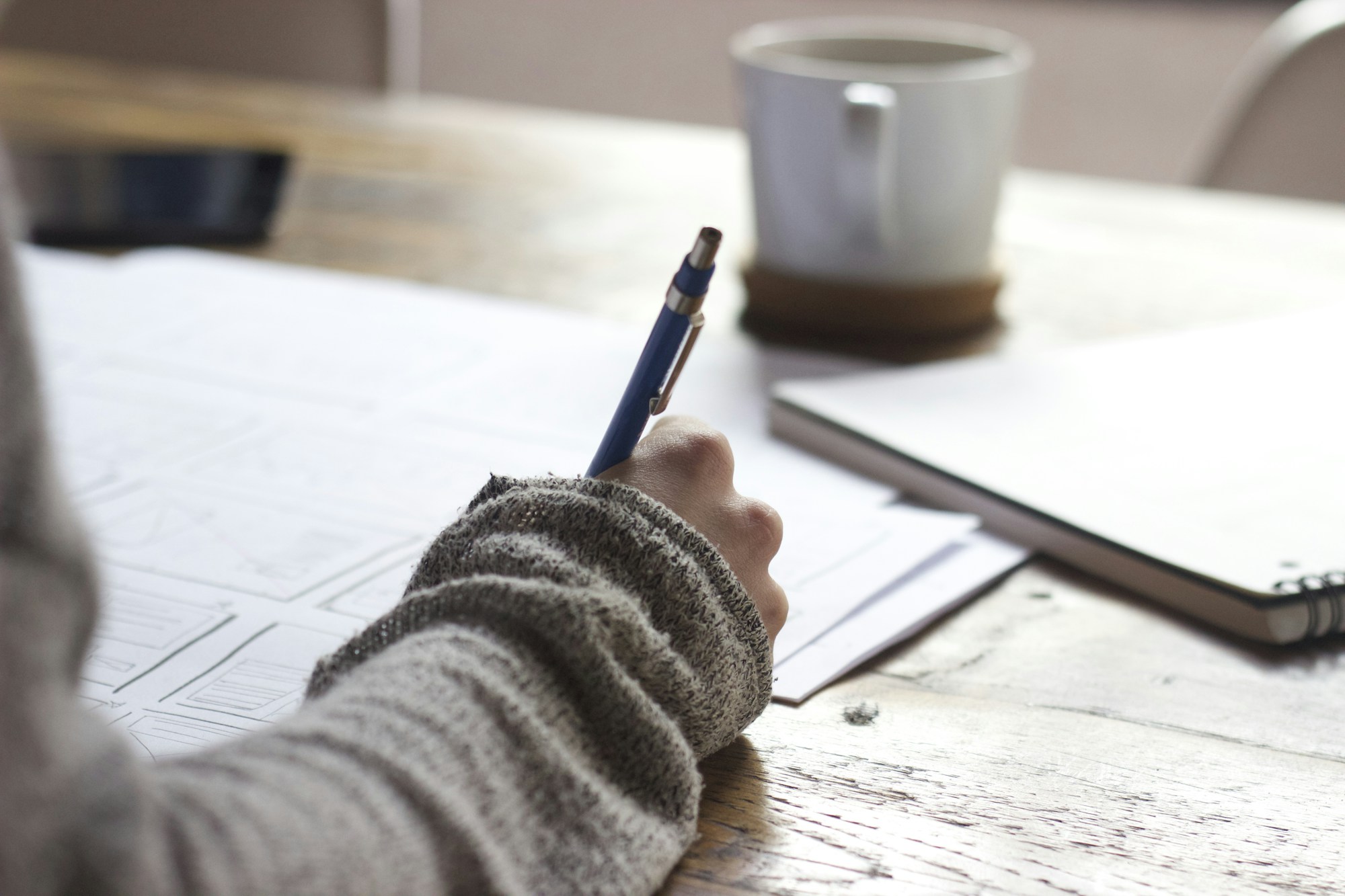 Researcher annotating documents at a working table